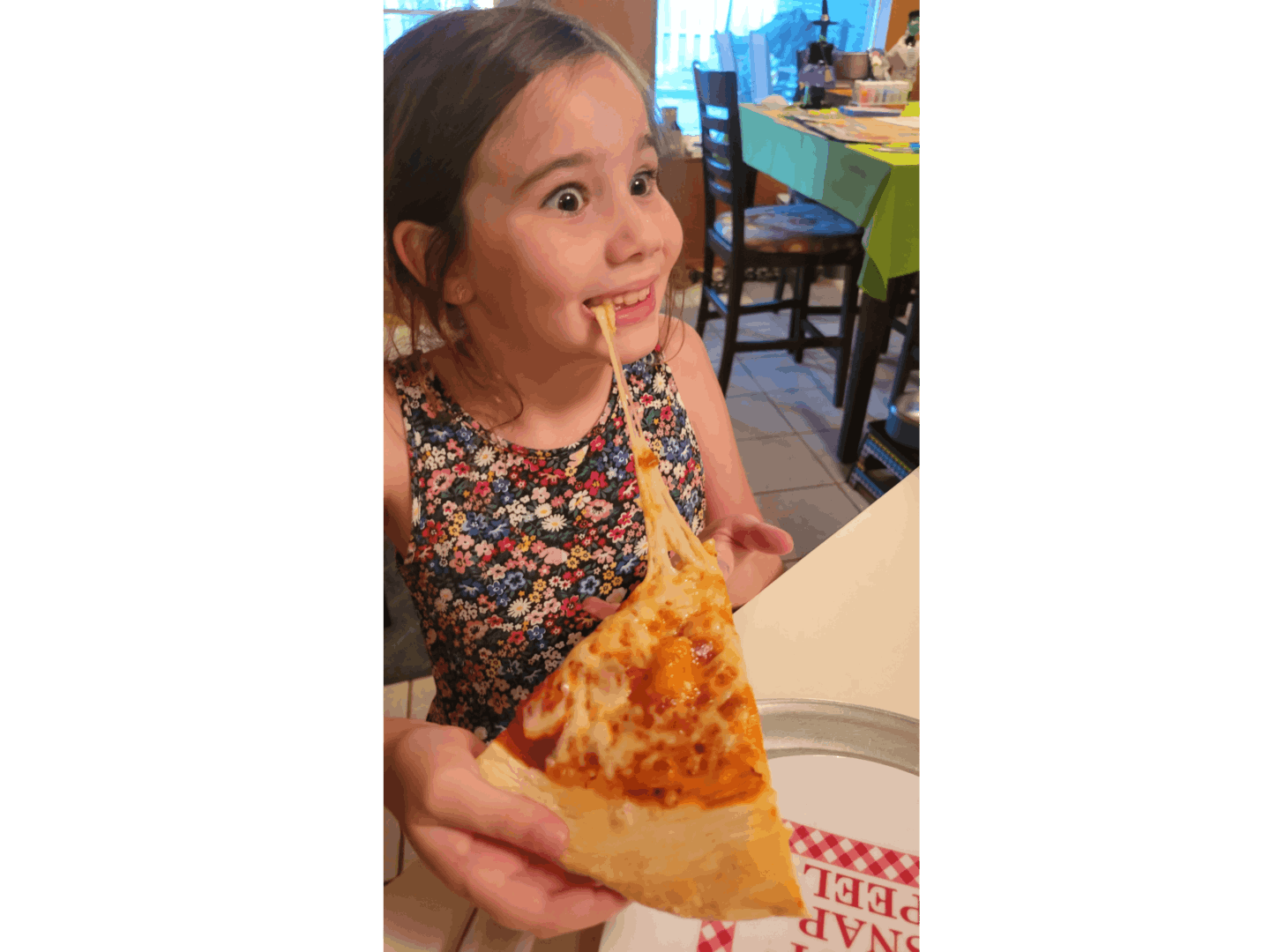 A girl eating a pizza inside a restaurant